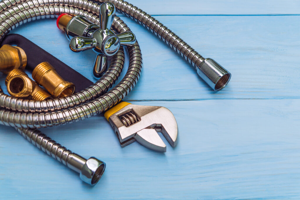 Plumbing tools and hose on blue boards were prepared by craftsman before repair